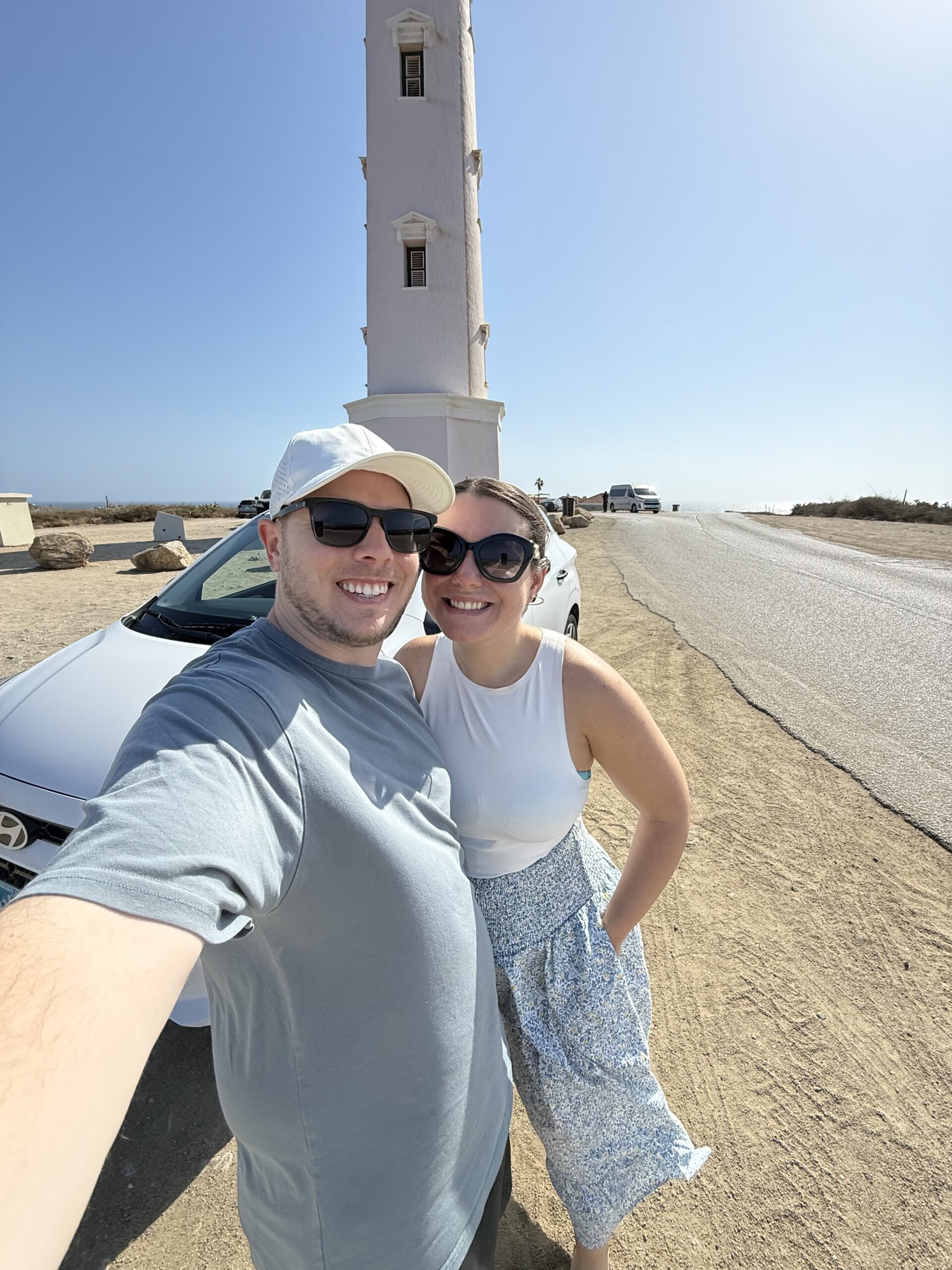 Selfie in front of the California Lighthouse on our first morning with the rental car — northwest tip of Aruba, one of the easiest drives on the island