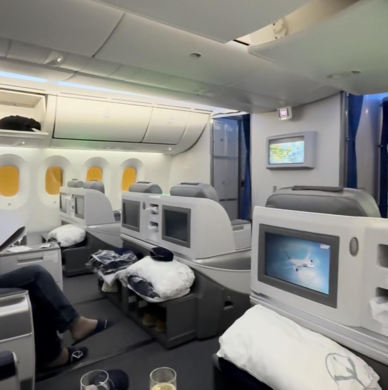 Looking down the LOT 787 business class cabin, showing the 2-2-2 rows and the 787's dimmable windows